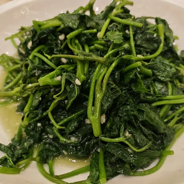 A plate of boiled wild greens dressed with olive oil.